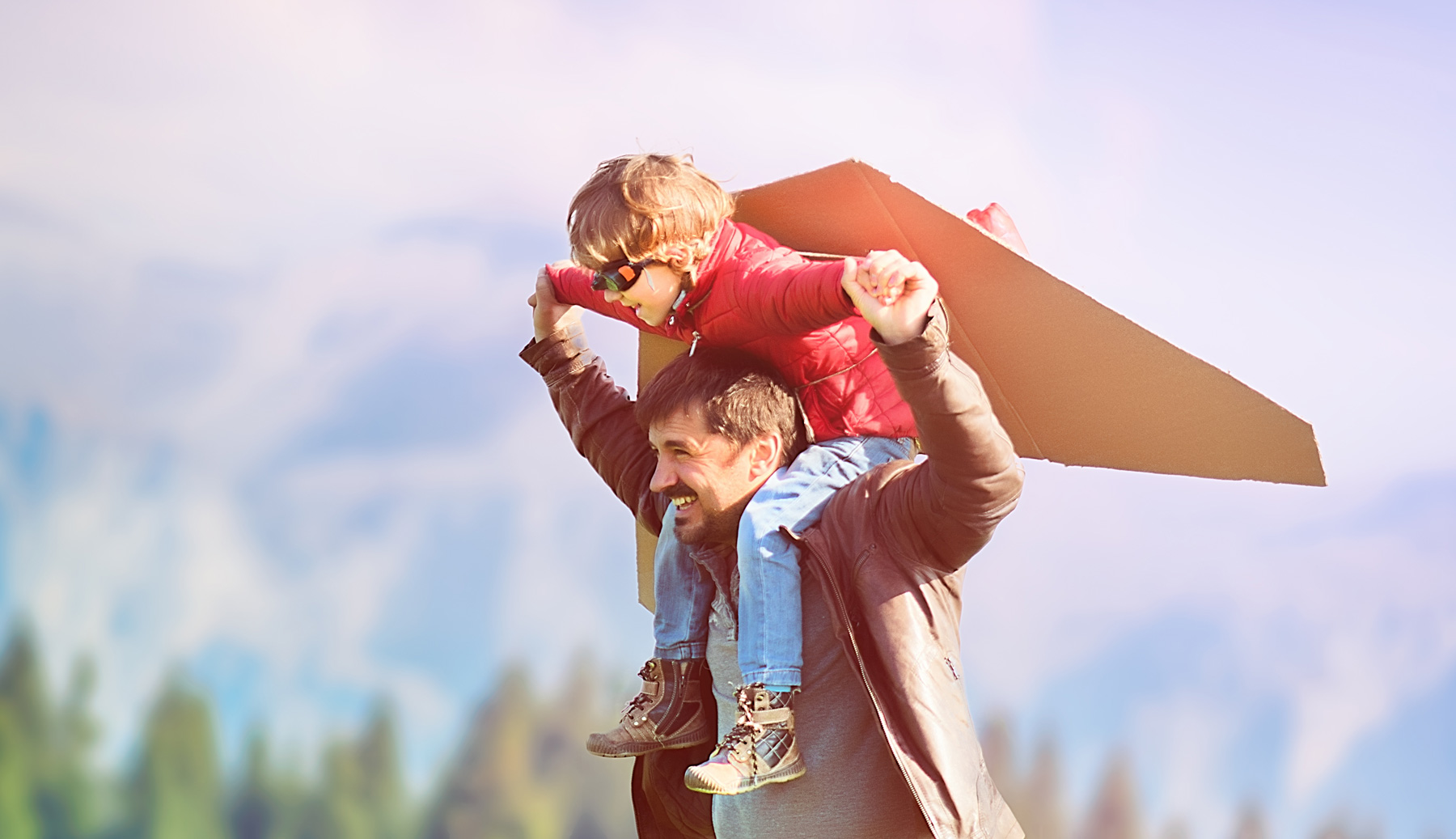 dad with son on his shoulders pretending to fly like an airplane