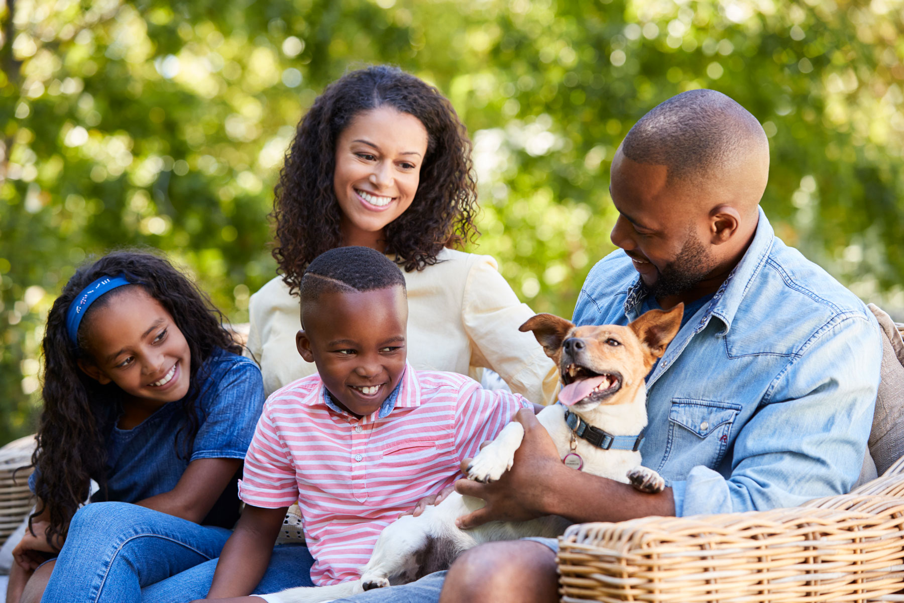 family outdoors with dog, smiling