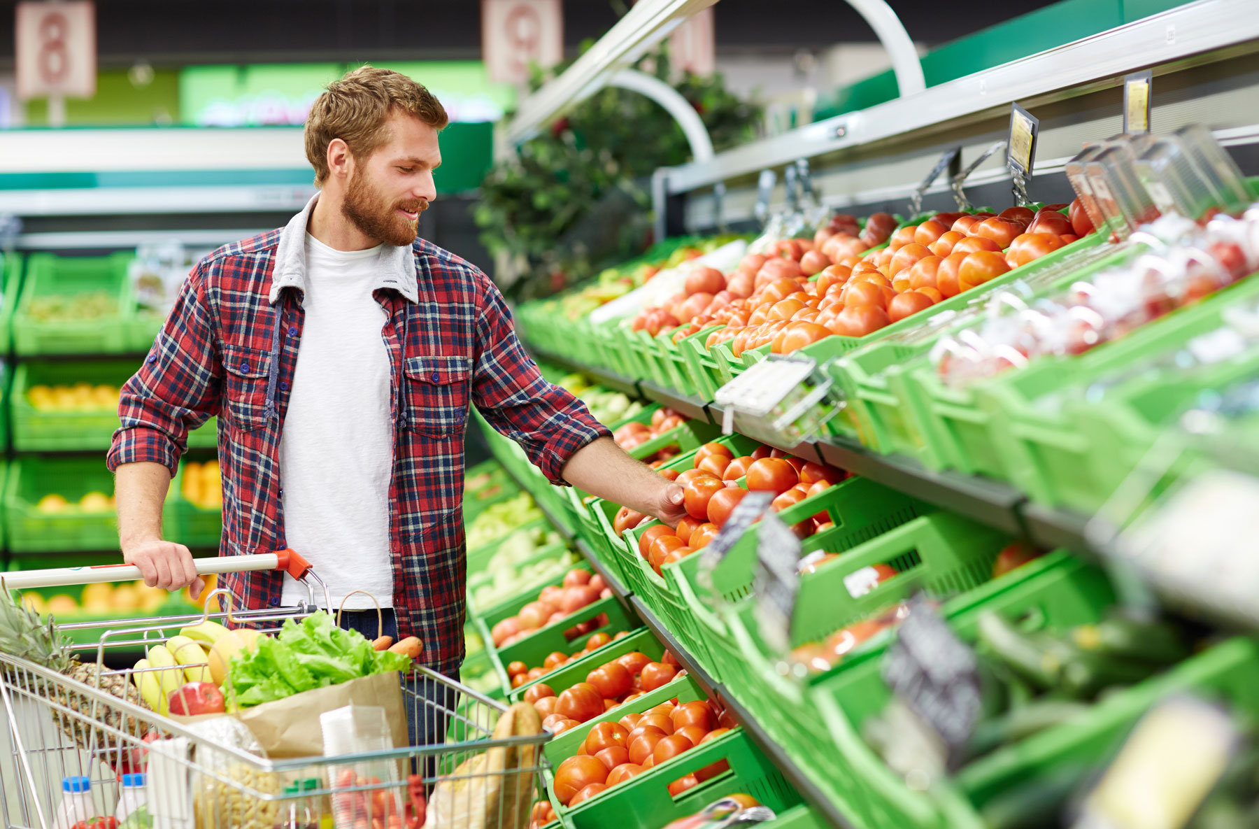 man shopping in produce aisle of grocery store