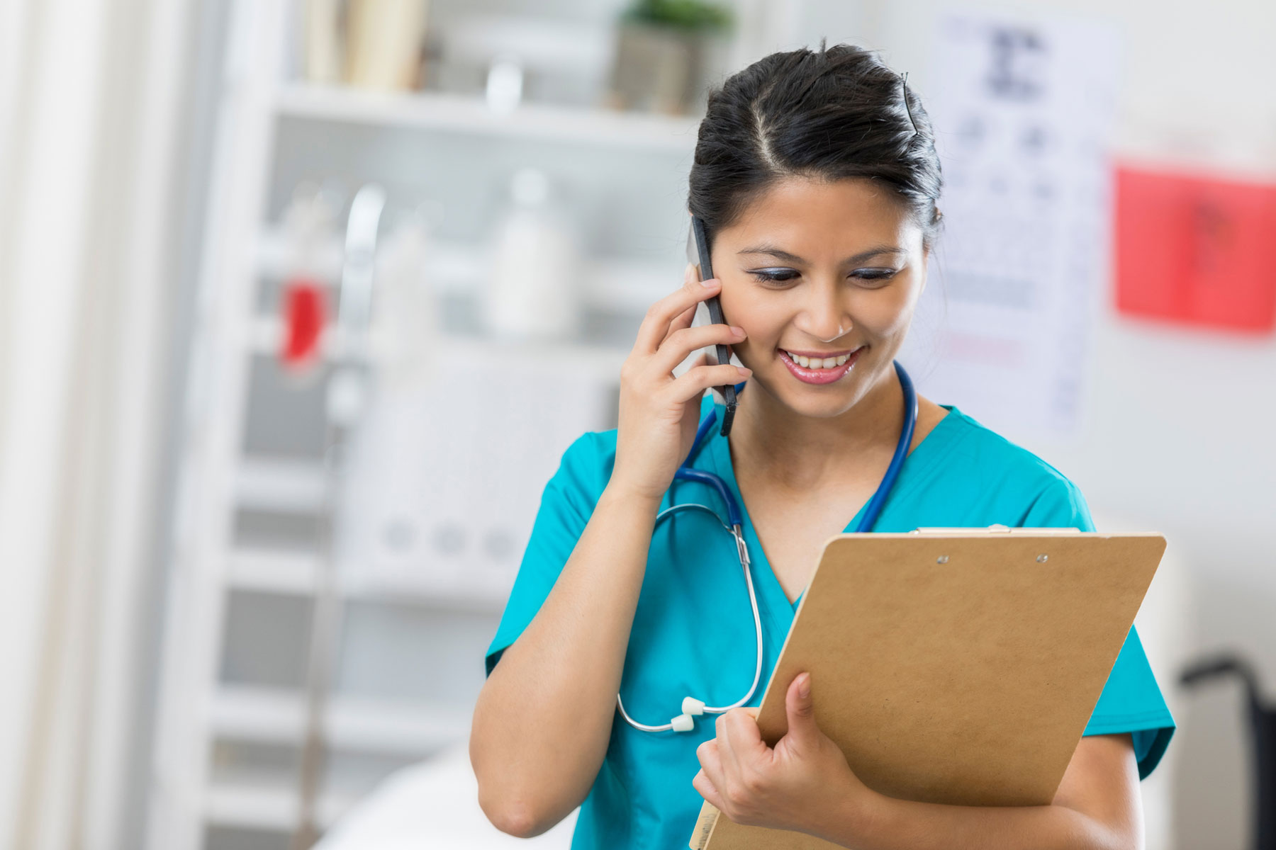 nurse with clipboard on phone