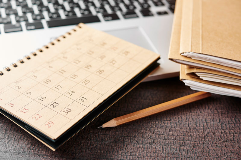 calendar, pencil, laptop, and file folders