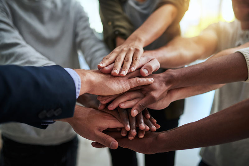 diverse hands together in office