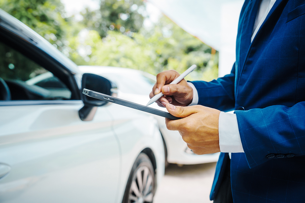 Man with a clipboard next to an accident